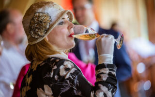 Weiblicher Gast in historischem Kostüm mit Empfangssekt